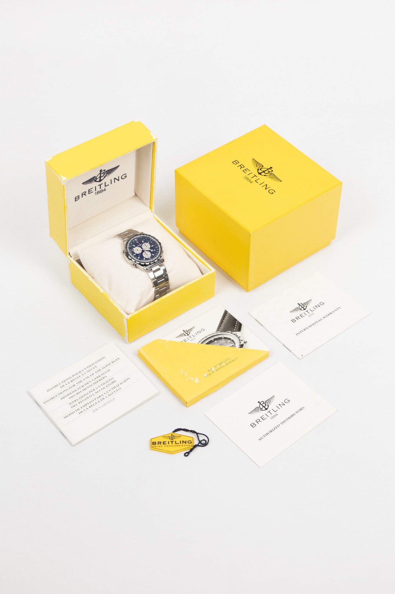 A full Breitling watch set displayed on a white background, including the Jupiter Pilot watch in a signature yellow box with manuals, warranty papers, and a hangtag.