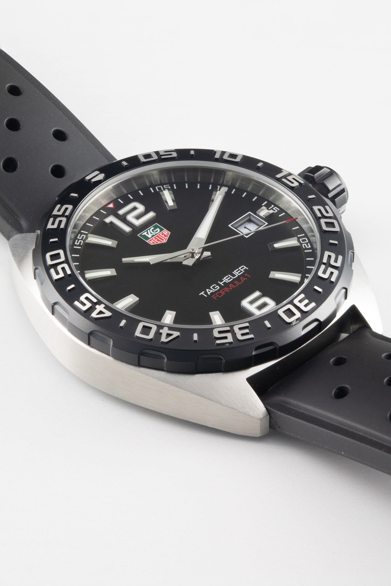 An angled macro shot of the watch head, emphasizing the texture of the black dial, the raised indices, and the brushed finish of the stainless steel lugs.