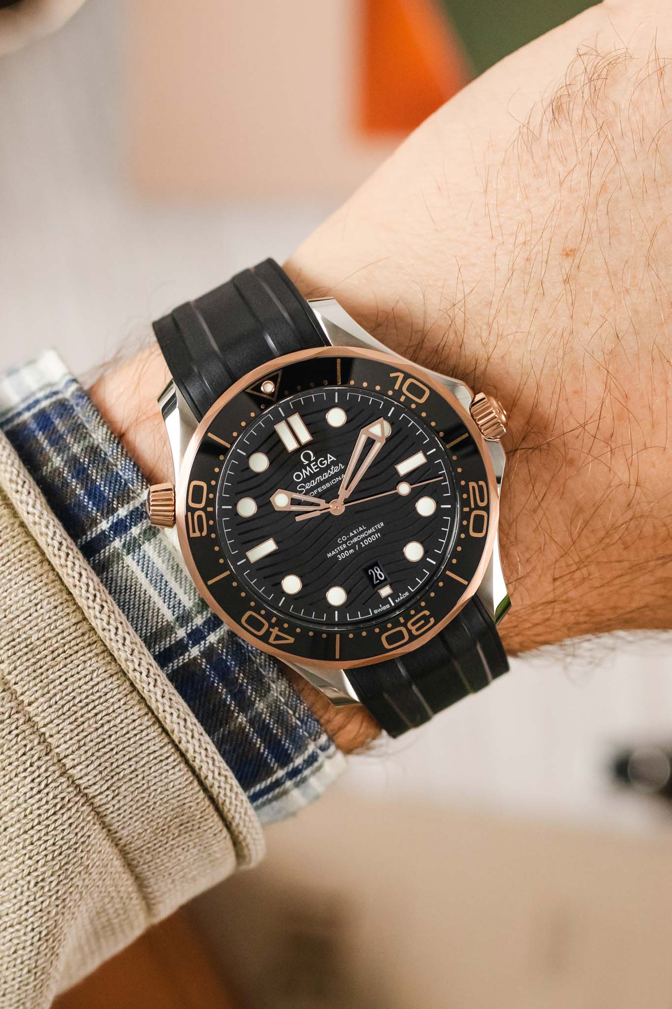 Wrist shot of a two tone dive watch in Sedna gold and Steel with ceramic black bezel